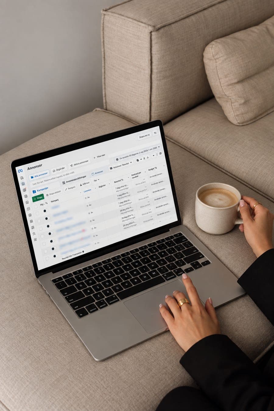 Laptop med Meta Ads Manager öppen i en soffa, bredvid en kaffekopp